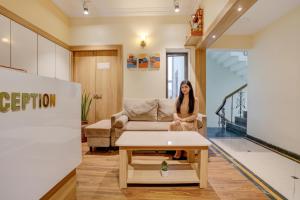 奥兰加巴德Via Heritage Palace - CIDCO Bus Stand的一位女士坐在客厅的沙发上