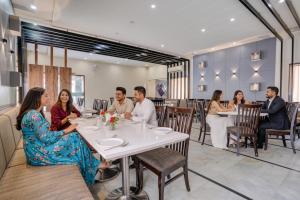 奥兰加巴德Via Heritage Palace - CIDCO Bus Stand的一群人坐在餐厅的一张桌子旁