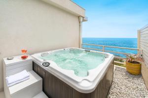 a jacuzzi tub on a balcony overlooking the ocean at Villa Hermes in Noto Marina