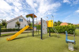une aire de jeux avec toboggan jaune et toboggan dans l'établissement Noordwijk Holiday Rentals, à Noordwijk