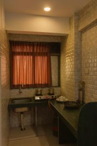 een keuken met een aanrecht, een wastafel en een raam bij A R Residency in Navi Mumbai