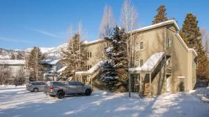 a house with a car parked in the snow at RMR: Balsam Lodge B4 Condo in The AspensWilson WY in Wilson