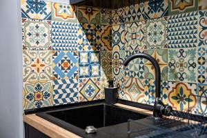 Il dispose d'une cuisine avec un évier et un mur carrelé. dans l'établissement Kaktus Chill & Sleeping - 50 m od Rynku, à Racibórz 131 autres photos