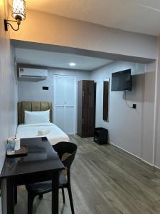 a hotel room with a bed and a table and a television at Lux City Hotel in Seremban +39 photos