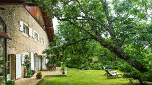een binnenplaats naast een bakstenen gebouw met een bankje bij Domaine des Rochaules 