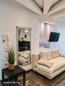 Una sala de estar con un sofá y un espejo. en Hotel George suite 2, en Limenas