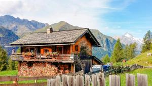 una pequeña casa en una colina con montañas en el fondo en Almhütte Haritzer, en Schachnern