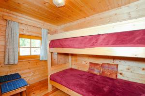 1 dormitorio con 2 literas en una cabaña de madera en Almhütte Haritzer, en Schachnern