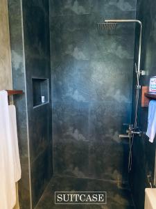 Suitcase في أمبالانغودا: دش مع باب زجاجي في الحمام