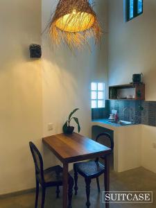 Suitcase في أمبالانغودا: غرفة طعام مع طاولة وكراسي ومطبخ