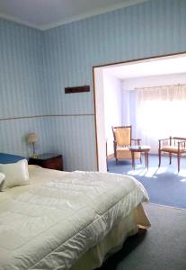 ein Schlafzimmer mit einem Bett, einem Tisch und einem Stuhl in der Unterkunft Hosteria Pastoral & Spa in La Cumbre