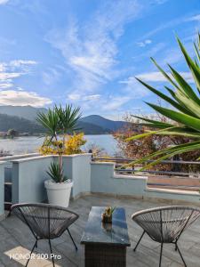 un patio con 2 sillas y mesas y vistas al agua en Hotel George suite 2, en Limenas