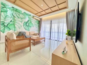 ein Wohnzimmer mit einem großen Wandbild aus Blättern an der Wand in der Unterkunft Country Garden Danga Bay by Luxecocoo CK Johor Bahru in Johor Bahru
