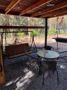 un patio con mesa, sillas y banco en Cabañas las Palmeras de Colbun, en Linares