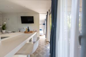 a kitchen and living room with a white counter and chairs at Vibra Glamping in Cavallino-Treporti