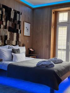une chambre avec un grand lit avec un éclairage bleu dans l'établissement Mała Anglia Deluxe Rooms & SPA, à Sopot