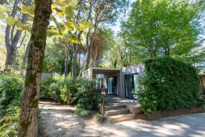 a tiny house in the woods with a tree at Vibra Glamping in Cavallino-Treporti