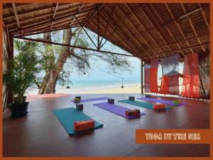Un grupo de esterillas de yoga frente a la playa en Sanctuary Hostel - Art & Adventure, en Phra Ae beach