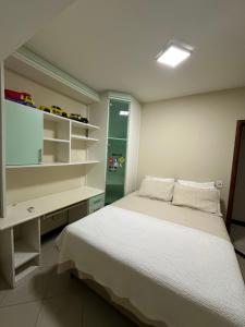 ein Schlafzimmer mit einem Bett, einem Schreibtisch und Regalen in der Unterkunft Apartamento familiar com vista para o mar em Guarapari Praia do Morro, frente ao Marlim!!! in Guarapari + 23 Fotos