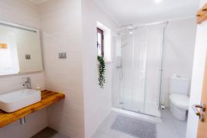 ein weißes Badezimmer mit Waschbecken und Dusche in der Unterkunft Surf Lodge Santa Cruz in Silveira + 47 Fotos
