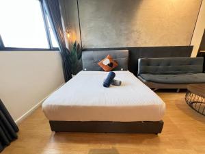 a bedroom with a bed and a chair in a room at Chambers by Lumira Haven Klcc in Kuala Lumpur