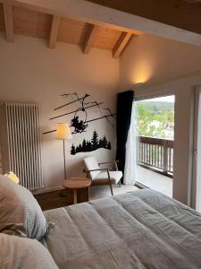 1 dormitorio con 1 cama y una rama de árbol en la pared en Appartamento La Téza, en Lavarone