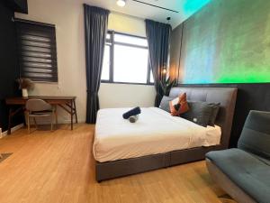 a bedroom with a bed and a chair and a desk at Chambers by Lumira Haven Klcc in Kuala Lumpur