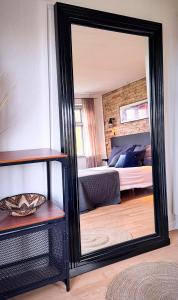 un miroir en face d'une chambre avec un lit dans l'établissement Modern vacation Home - Close to sea and nature., à Hejls 19 autres photos