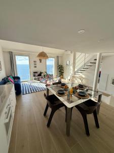 Una cocina y una sala de estar con mesa de comedor. en Casa Favelas, Vue Mer et Proche de Monaco, en Cap d'Ail