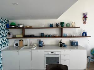 una cocina con armarios blancos, fregadero y estanterías en Casa Favelas, Vue Mer et Proche de Monaco, en Cap d'Ail 75 fotos más