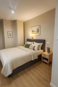 a bedroom with a large bed with white sheets and pillows at Pieńki i Towarzystwo 6 niezależnych apartamentów 3 min od Suntago in Wręcza