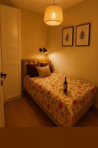 a bedroom with a bed with a bottle of wine on it at Pieńki i Towarzystwo 6 niezależnych apartamentów 3 min od Suntago in Wręcza