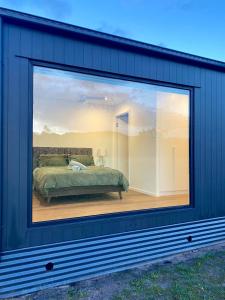 Una gran ventana de un dormitorio con una cama. en Grampians View Retreat, en Halls Gap