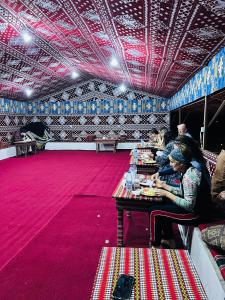 瓦迪拉姆Desert Key Camp的一群人坐在房间里的桌子旁 更多38张照片