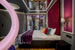 una camera da letto con un grande letto con una parete rosa di Grey Champagne Spa by Secret Apartament a Danzica