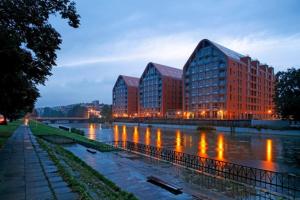 un gruppo di edifici vicino a un fiume di notte di Grey Champagne Spa by Secret Apartament a Danzica