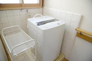 Waschmaschine und Trockner in einer kleinen Küche in der Unterkunft 宇都宮ゲストハウス花ニ嵐 in Utsunomiya