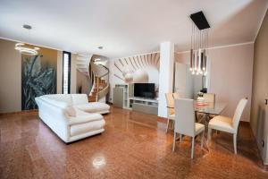 un soggiorno con mobili bianchi e tavolo di Duo LUXURY SUITES a Verona