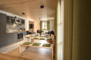 a kitchen with a table with green cushions at Haus Sternenhimmel in Oberammergau