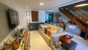 uma sala de estar com um sofá e uma escada em Guarajuba Oliveira em Camassari