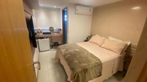 um pequeno quarto com uma cama e uma televisão em Guarajuba Oliveira em Camassari mais 32 fotografias