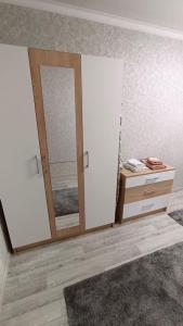 una stanza con specchio, cassettiera e porta di Квартира в Центре Шымкента Плаза a Shymkent