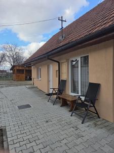 zwei Stühle und eine Bank außerhalb eines Hauses in der Unterkunft Casa O&A in Cristian