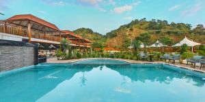 a pool at a resort with a mountain in the background at KING'SWAY Hotel & Resort in Dūngarpur