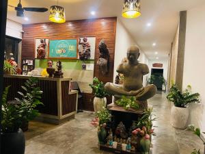 una tienda con una estatua de un hombre sentado en el mostrador en Chhouy Vathna Angkor Boutique, en Siem Reap 39 fotos más