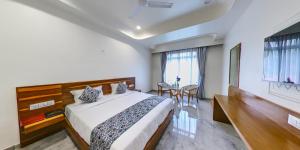 Un dormitorio con una cama y una mesa y sillas. en KING'SWAY Hotel, en Dūngarpur
