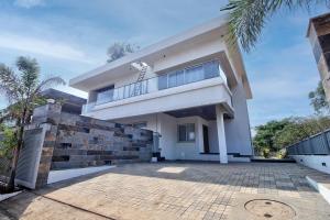 uma grande casa branca com uma varanda em Gardenia Villa by Ovi Resort em Jāmb