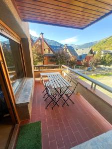 een balkon met een tafel en stoelen erop bij NEGUA Vielha in Vielha