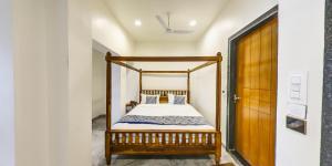 Un dormitorio con una cama con marco de madera. en KING'SWAY Hotel, en Dūngarpur