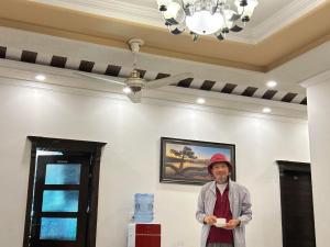 a man standing in a room with a ceiling at Grand Residency Guest House in Islamabad
